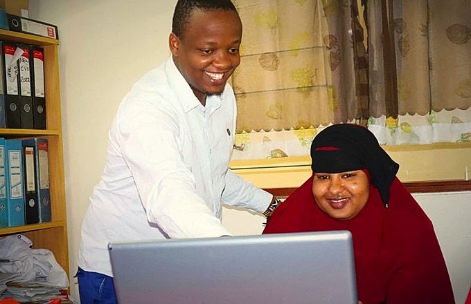 Atlas College ICT student and tutor collaborating at laptop