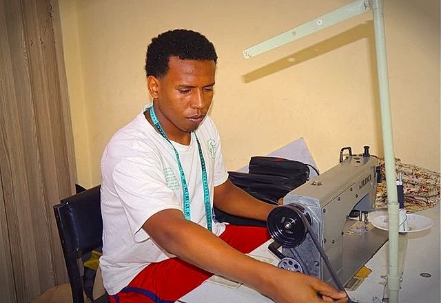 Atlas College tailoring and fashion design student at industrial sewing machine